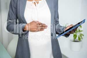 Pregnant businesswoman looking at tablet