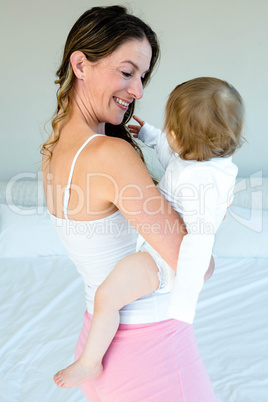 smiling brunette woman holding a playful baby