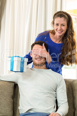 Woman giving a surprise gift to her man