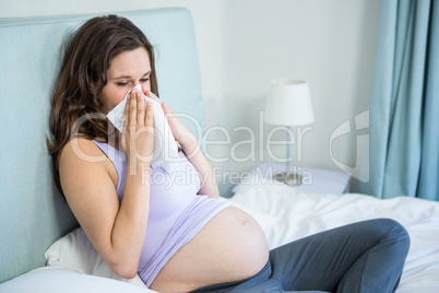 Pregnant woman blowing her nose