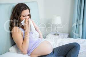 Pregnant woman blowing her nose