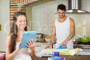Man ironing a shirt in kitchen