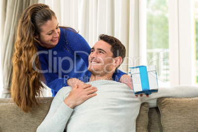 Woman giving a surprise gift to her man