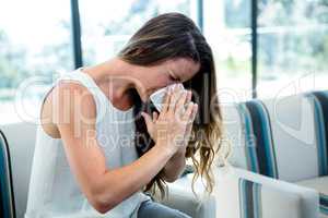 siczk woman sneezing into a tissue