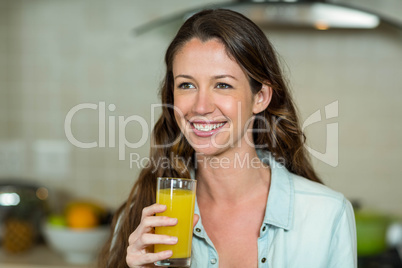 Young woman smiling while drinking juice