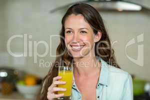 Young woman smiling while drinking juice