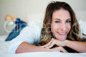 Woman lying on her bed smiling