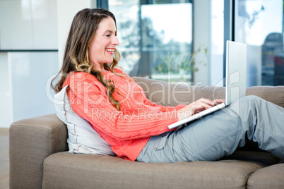 smiling woman typing on her laptop