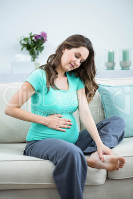 Pregnant woman massaging her tired feet