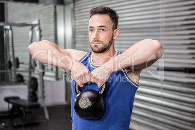 Muscular man lifting heavy kettlebell