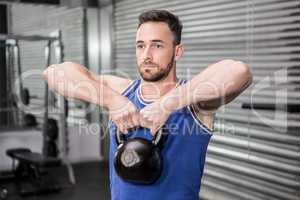 Muscular man lifting heavy kettlebell