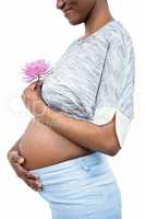 Pregnant woman with flower touching her belly