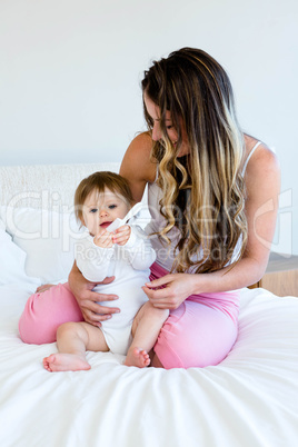 cute baby playing with a comb in a womans lap