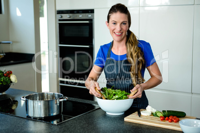 smiling woman tossing a salad