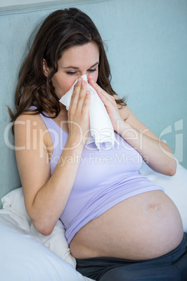 Pregnant woman blowing her nose