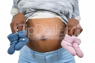 Pregnant woman holding baby shoe