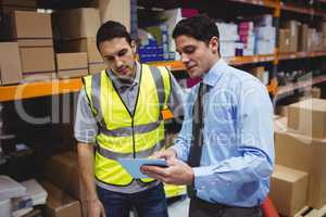 Manager showing tablet to worker