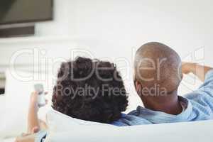 Rear view of couple watching television