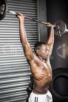 Shirtless man lifting barbell