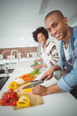 happy couple preparing vegetables