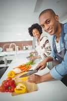 happy couple preparing vegetables