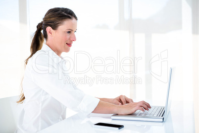 smiling business woman typing on her laptop