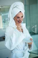 woman in a dressing gown holding a cup and saucer