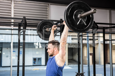 Muscular man lifting barbell