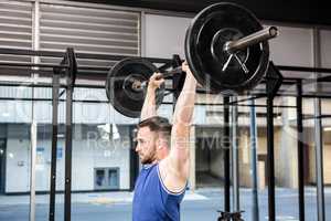 Muscular man lifting barbell