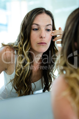 straight face woman inspecting her complexion