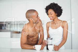 Happy couple drinking coffee in the kitchen