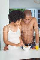 Happy couple eating breakfast in the kitchen