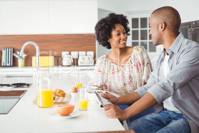 Smiling couple eating breakfast together in the kitchen
