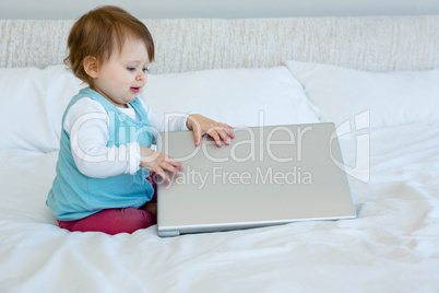 adorable baby playing with a laptop