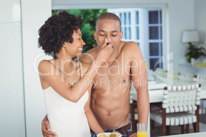 Happy couple eating breakfast in the kitchen