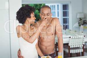 Happy couple eating breakfast in the kitchen