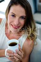 smiling woman holding a cup of coffee