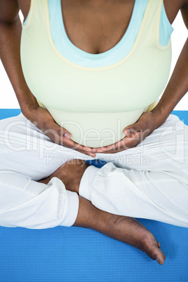 Pregnant woman meditating on mat