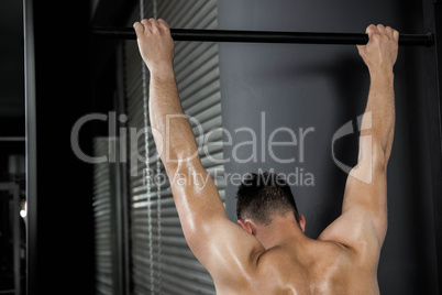 Shirtless man doing pull up