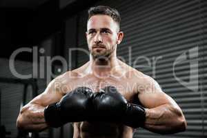 Determined shirtless man with boxe gloves