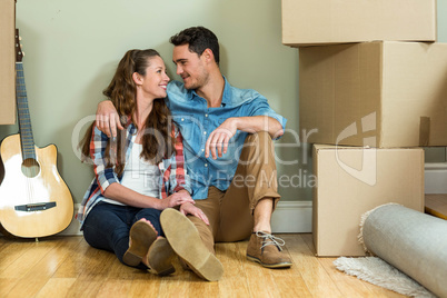 Young couple sitting together on the floor and smiling