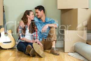 Young couple sitting together on the floor and smiling