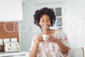 Portrait of smiling woman holding white cup