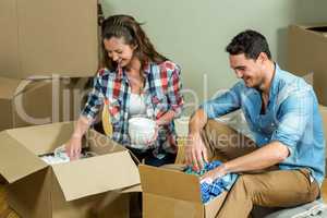 Young couple unpacking carton boxes