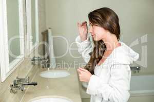 Beautiful woman looking in bathroom mirror