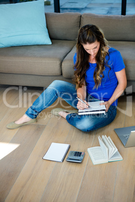business woman sitting on the floor writing