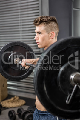 Shirtless man lifting barbell