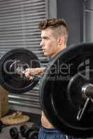 Shirtless man lifting barbell