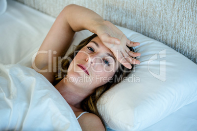 depressed brunette woman lying in bed