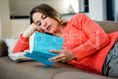 woman lying on the couch reading a book